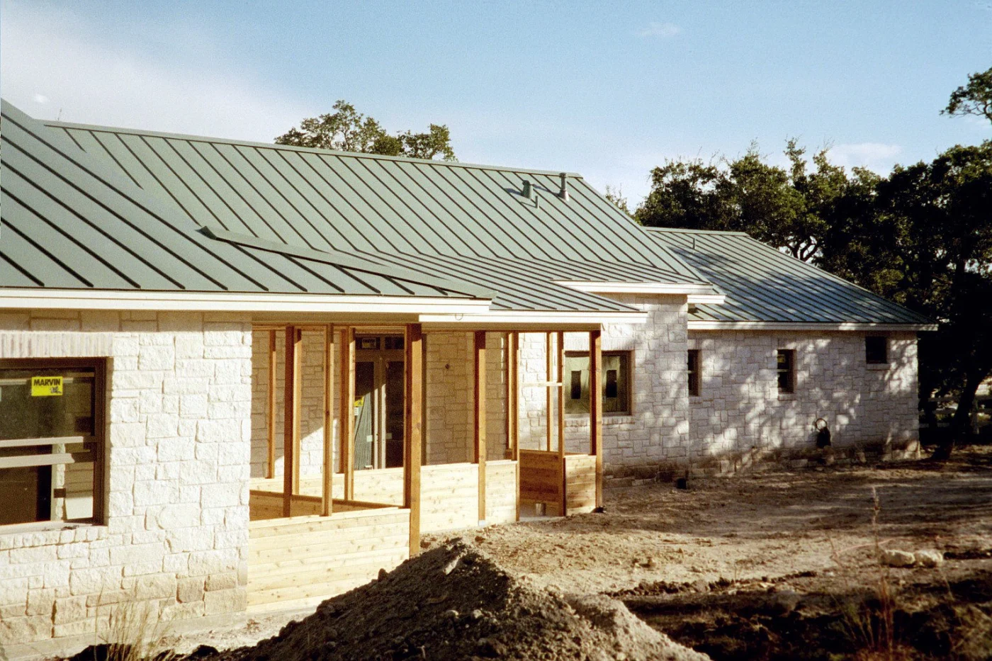 A green metal roof on a stone house near Bastrop, TX