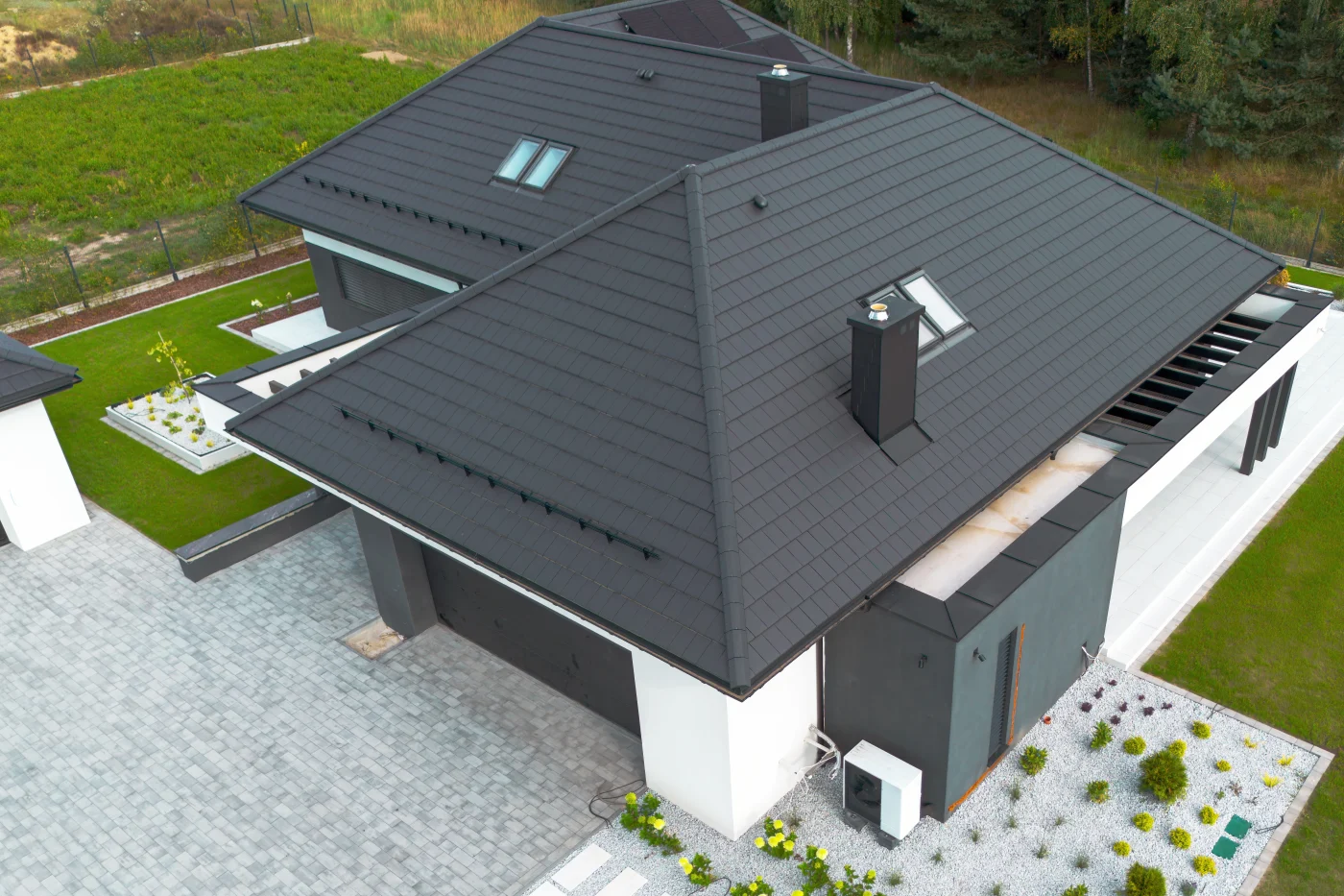 An aerial view above a metal roof on a house with skylights.