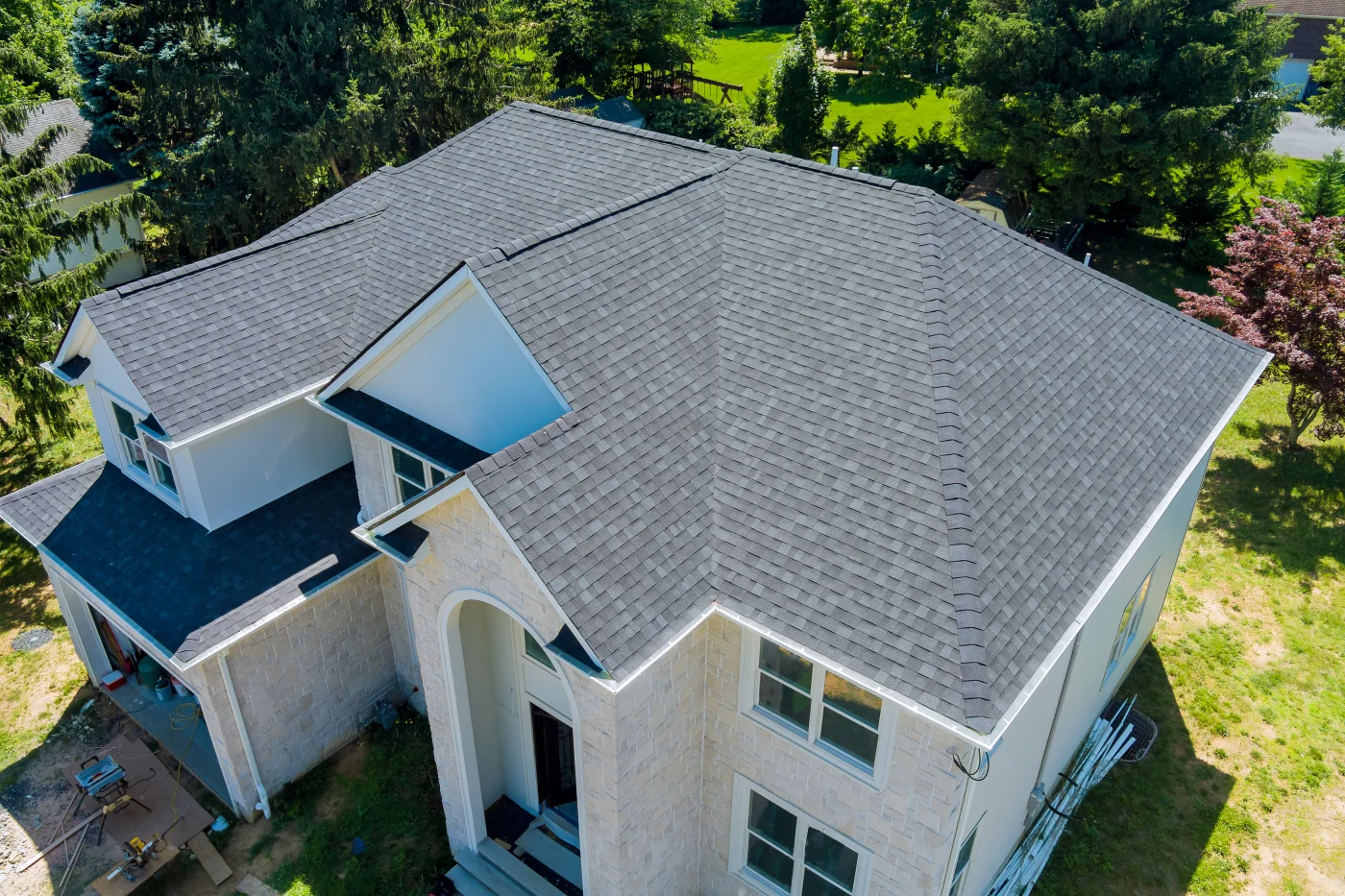 An aerial view of a new asphalt shingle roof on a two-story house.