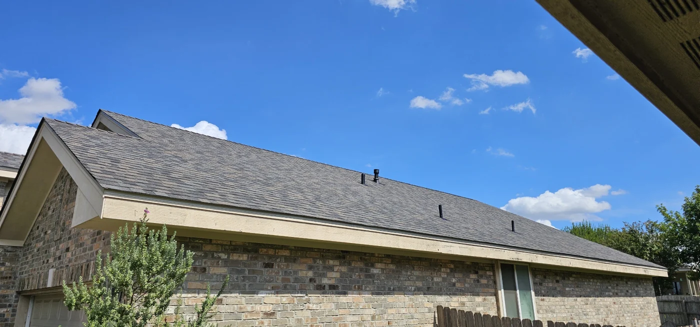 A new asphalt shingle roof on a brick house.