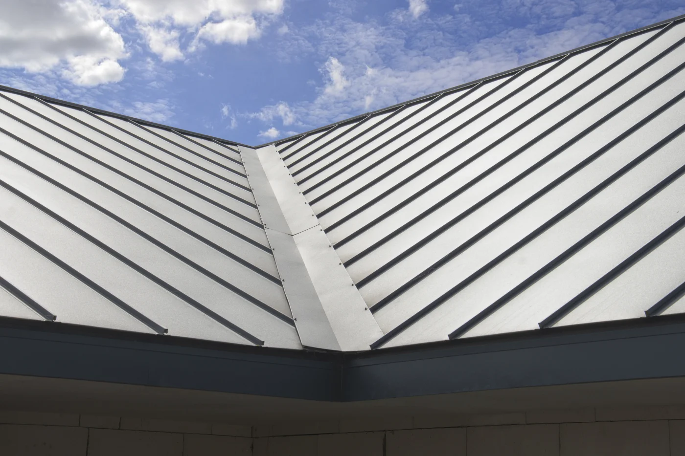 A close-up view of a corner of a metal roof on a building.