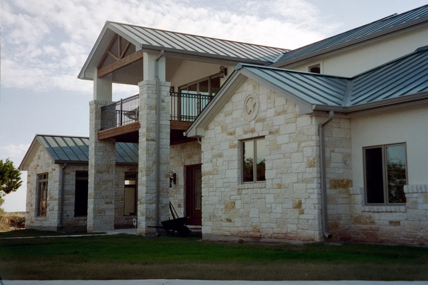 A close-up view of a metal roof on a two-story stone house.