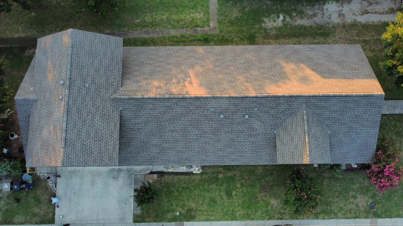 Aerial view of a residential roof featuring gray asphalt shingles in excellent condition.