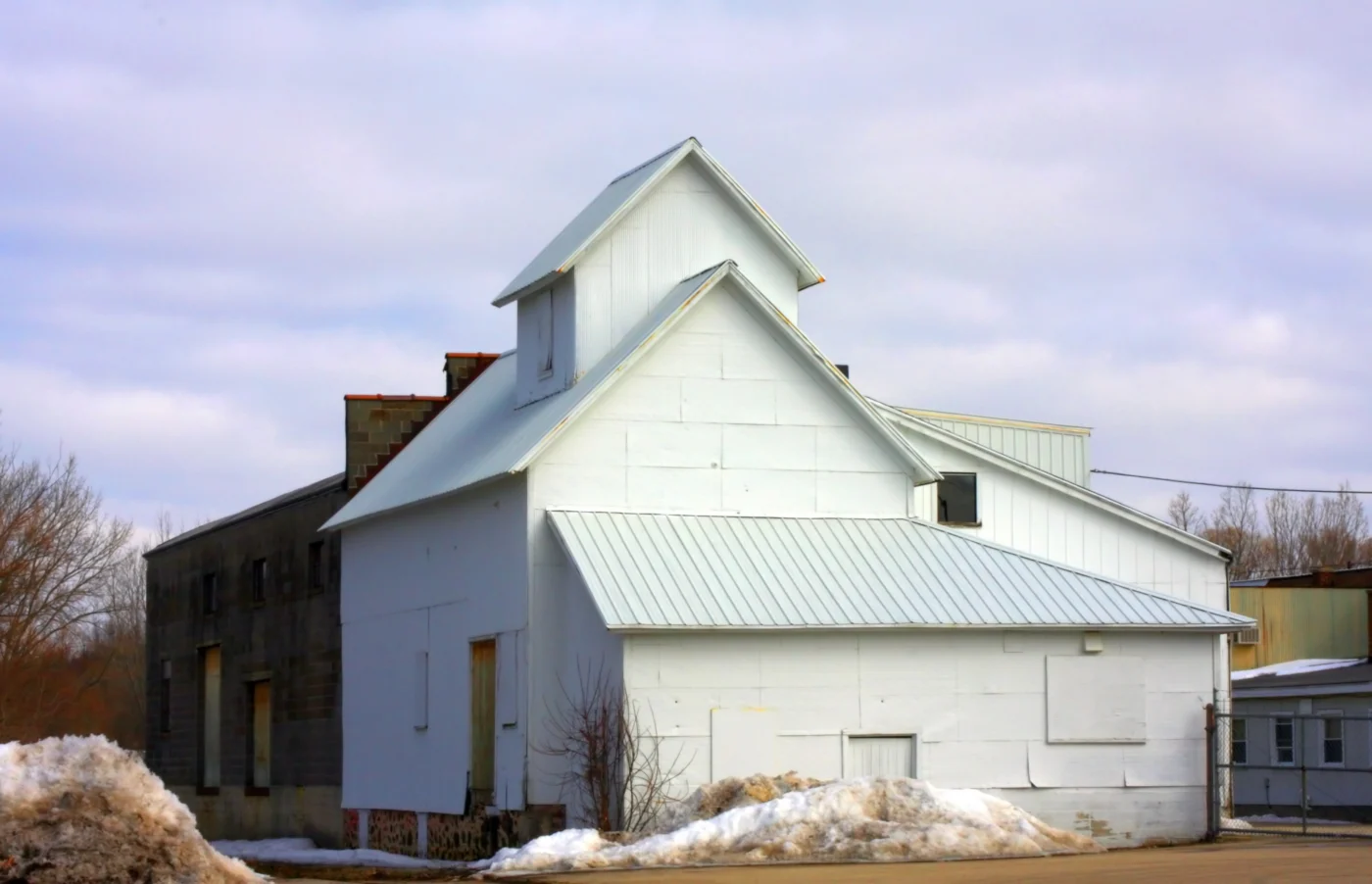 A light-colored standing seam metal roof installed on a white commercial-style building.