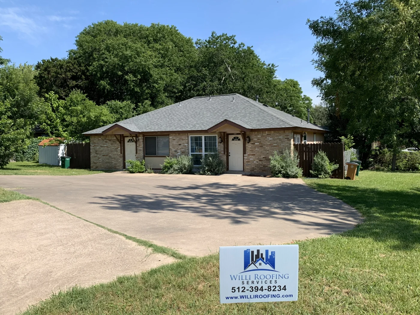 Single-story brick duplex with a newly installed asphalt shingle roof in Bee Cave, TX.