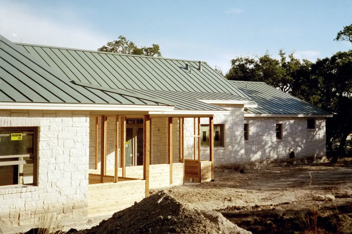 A one-story home with a green metal roof.