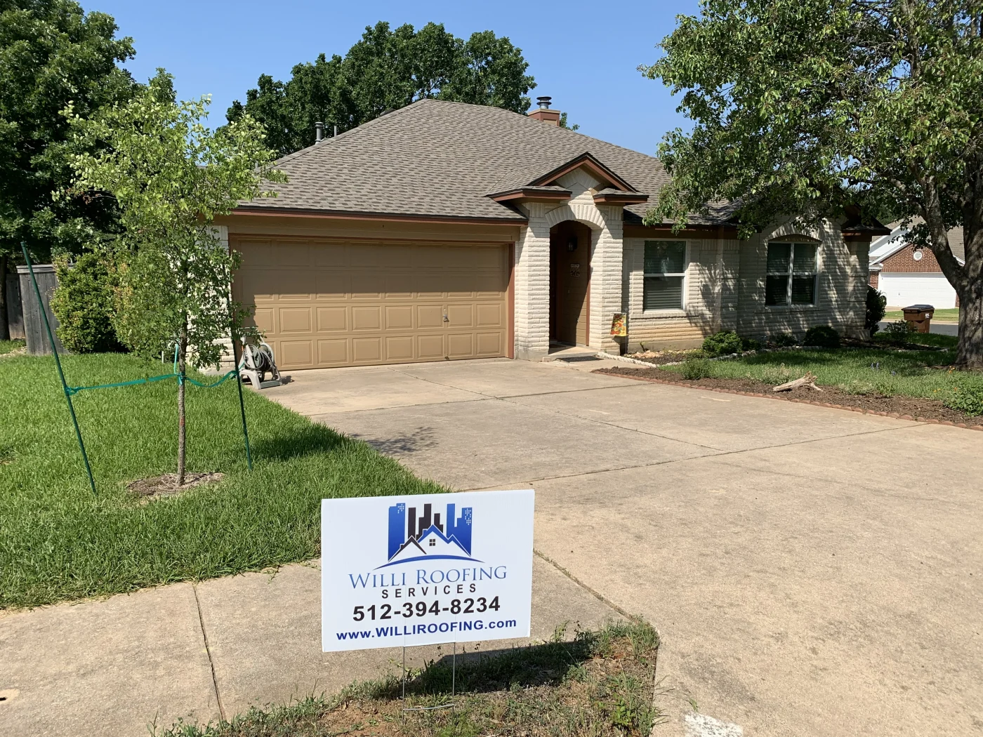 A grey asphalt shingle roof replacement on a two-story brick home in Bee Cave, TX.
