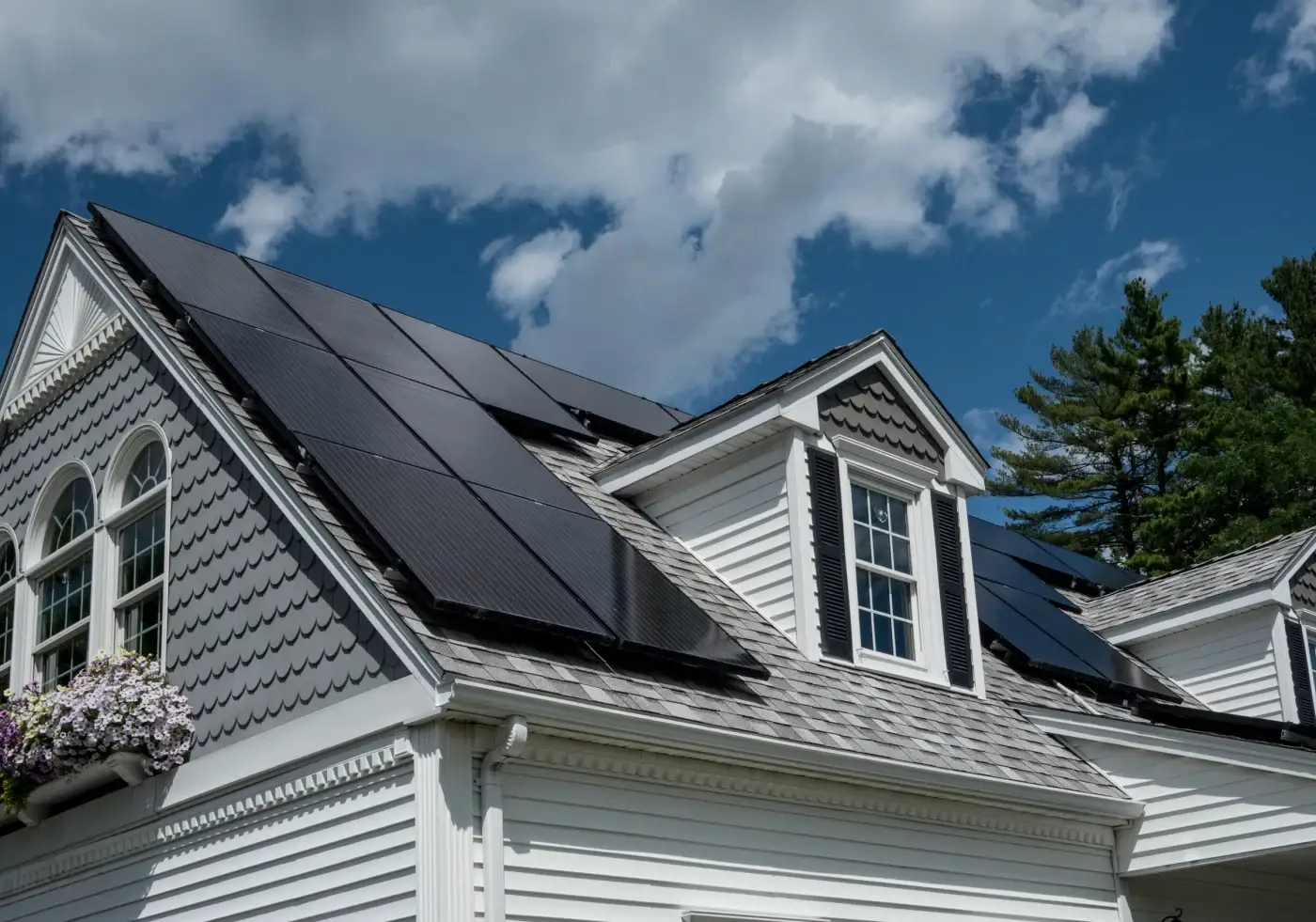 Upward view of solar panels on a gray shingle roof.