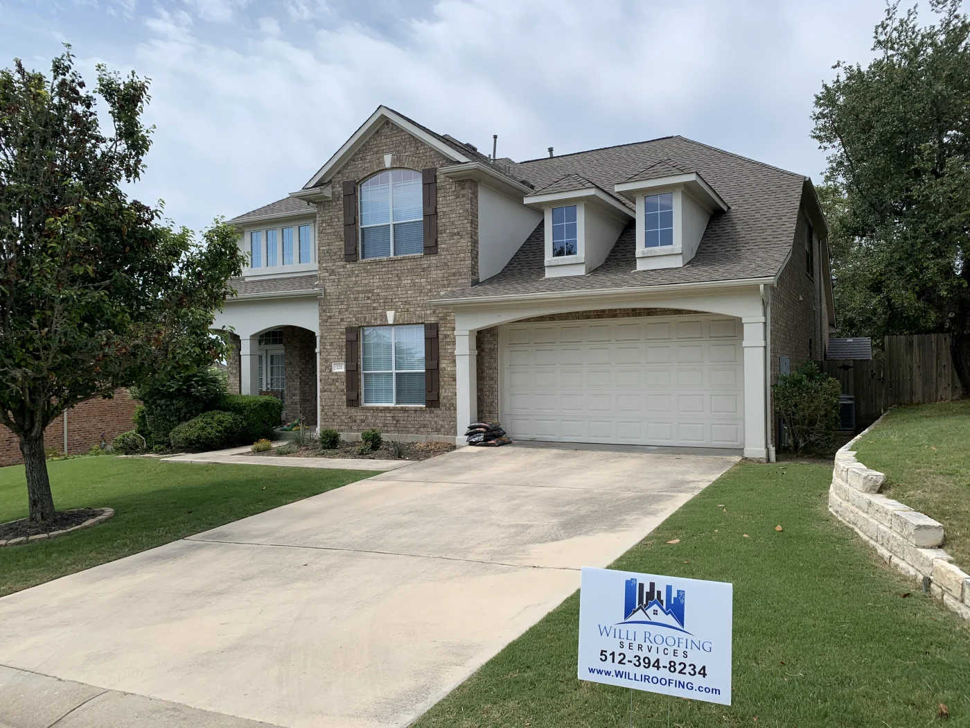 Single-story home with light stone and white siding exterior, featuring a newly installed asphalt shingle roof and attached garage.