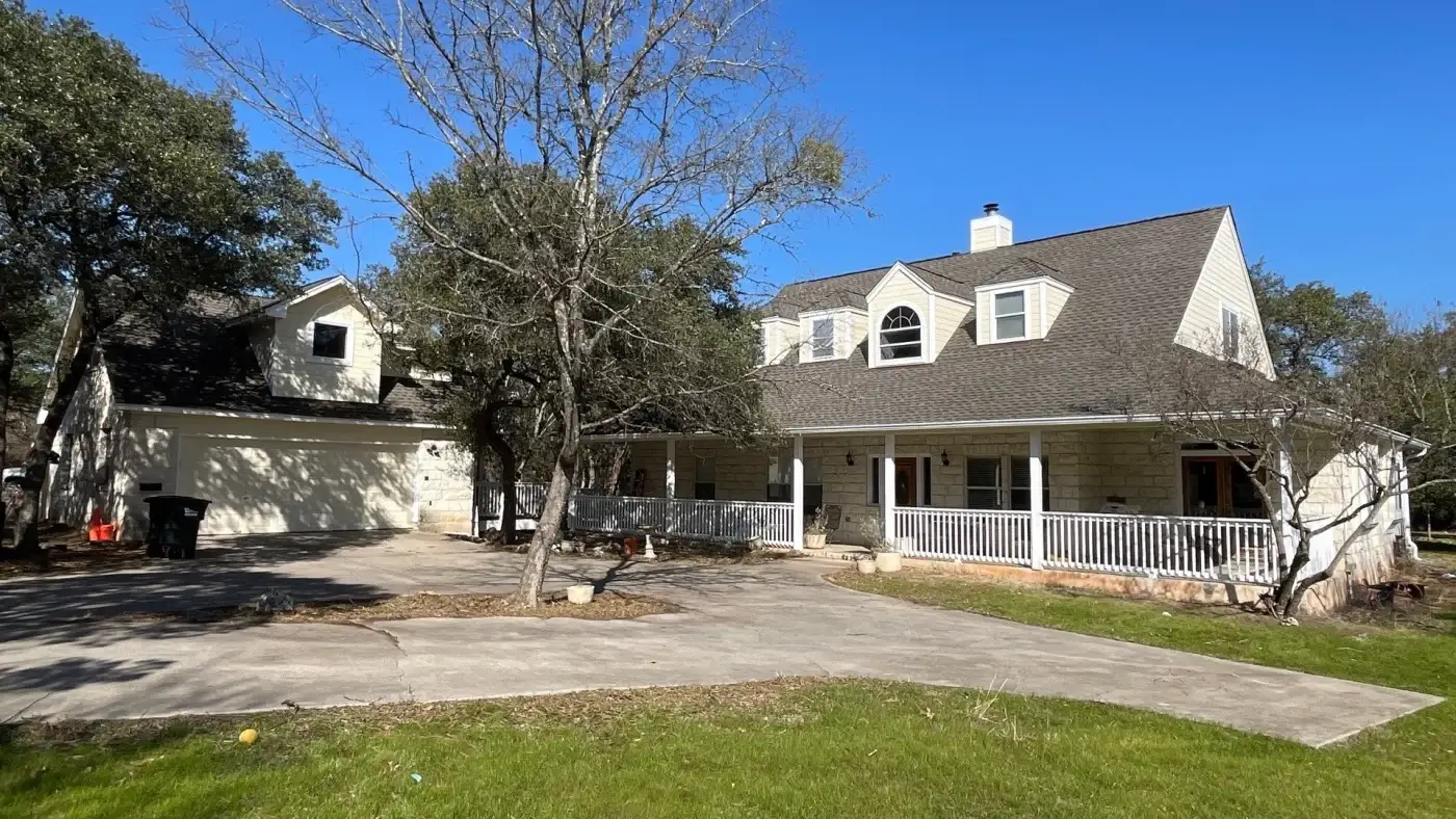 A tan brick house with a charcoal GAF asphalt shingle roof newly replaced.