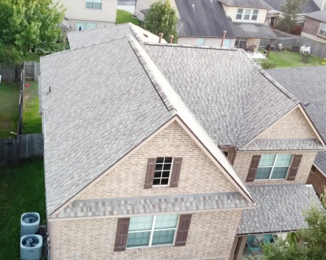 A beautiful white stone house with a new green metal roof on a Central Texas home.