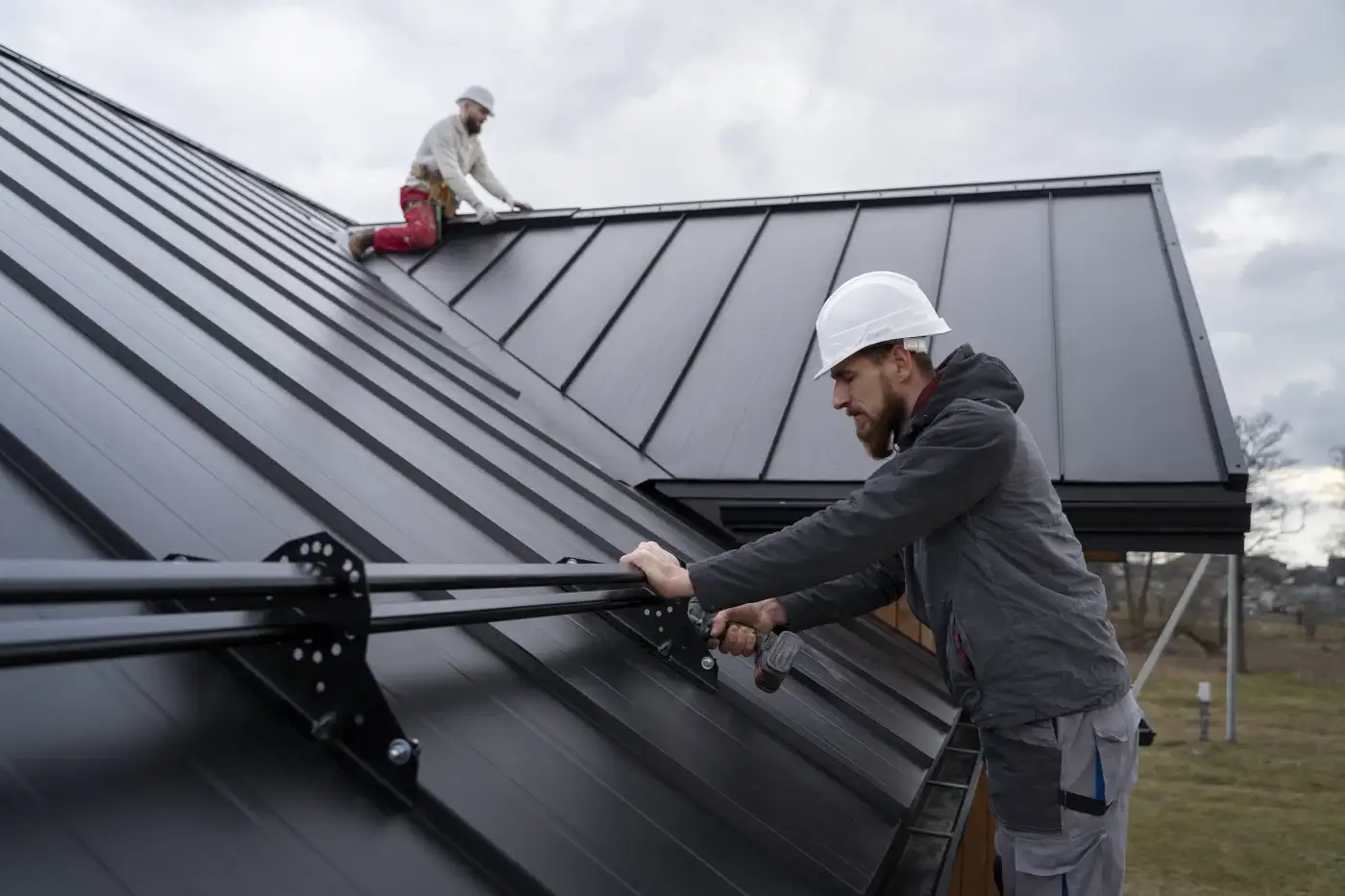 A house with wood siding and a black standing seam metal roof.