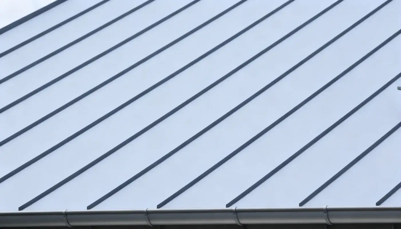 Angled view of a white stucco home with a metal roof.