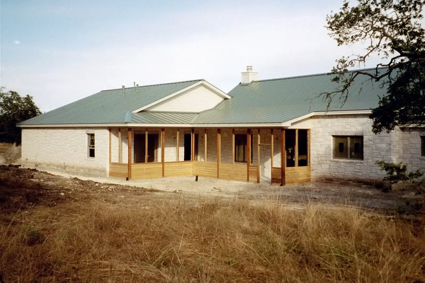 A modern two-story house featuring a stone exterior and a standing seam metal roof.