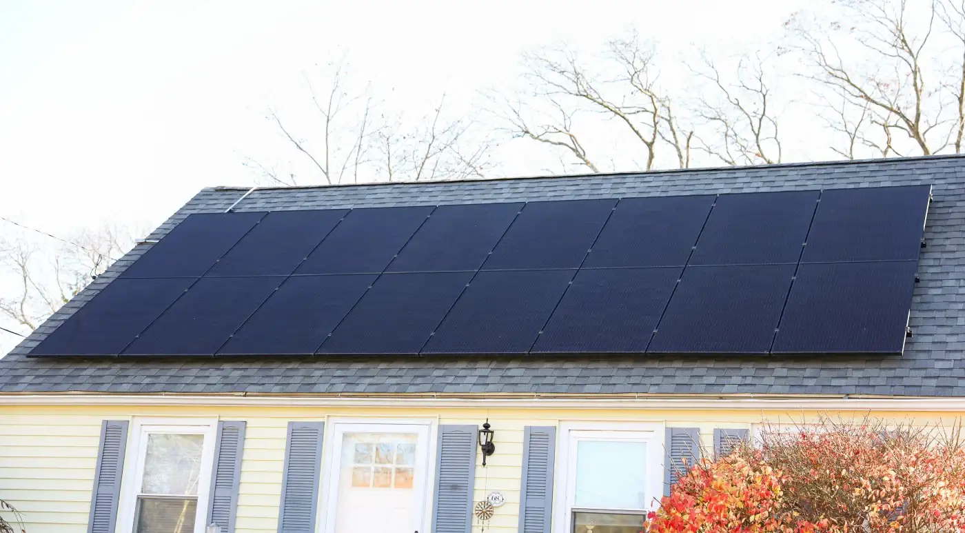 A brown asphalt shingle roof with solar panels installed.