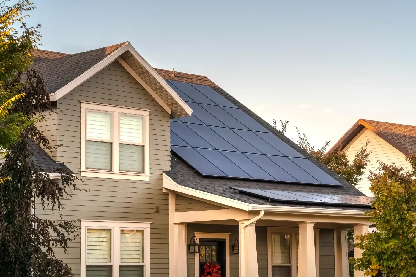 A home with older blue siding, a shingle roof, and solar panels.