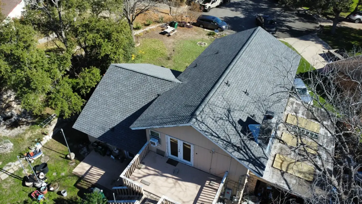 Overhead view of a new gray shingle roof taken from a drone.