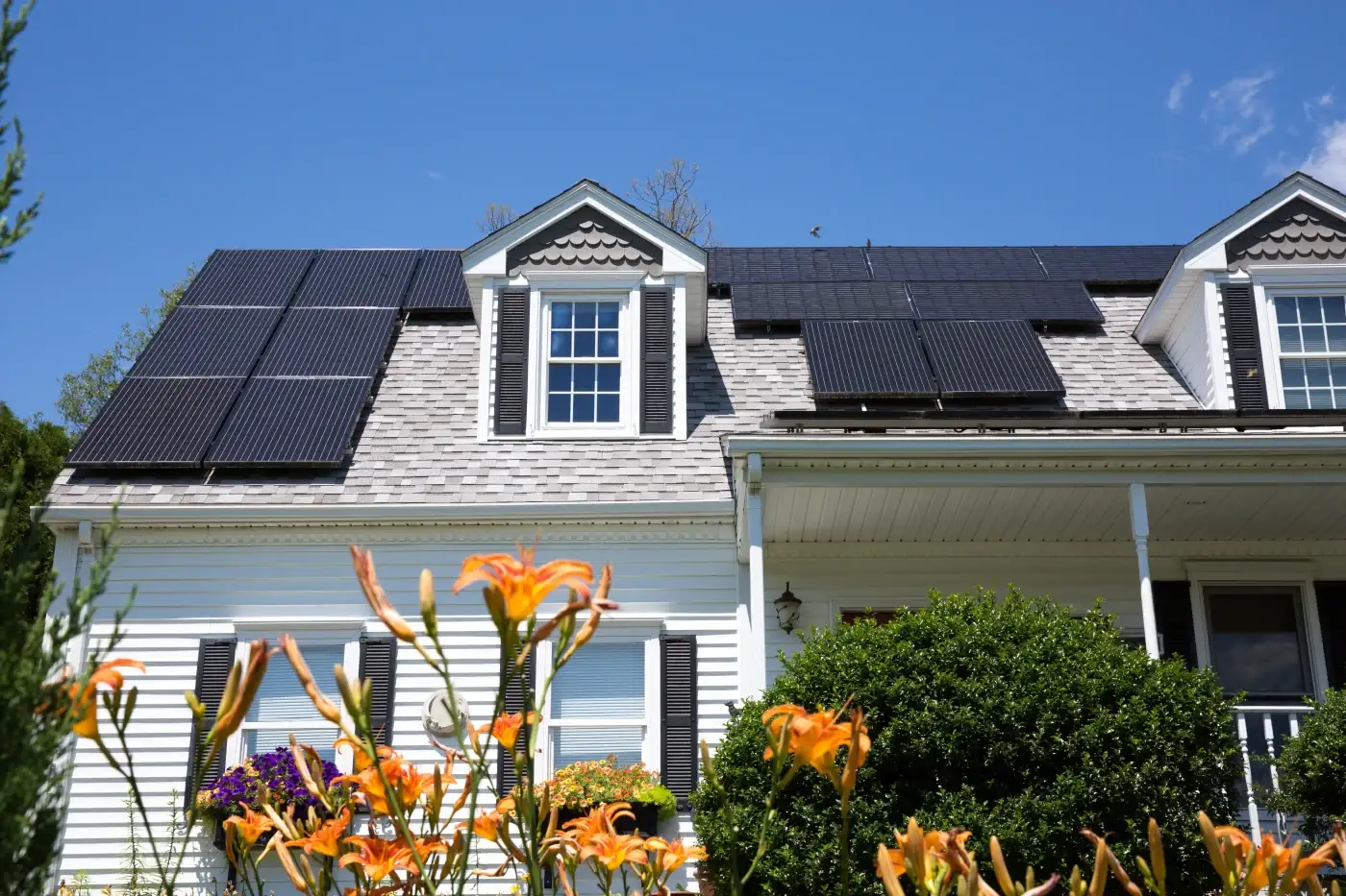 A large brick home with a tile roof and solar panels.