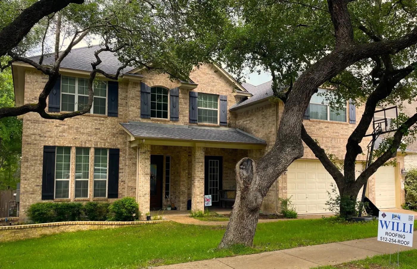 A light gray GAF architectural asphalt shingle installation on a white Bastrop, TX home.