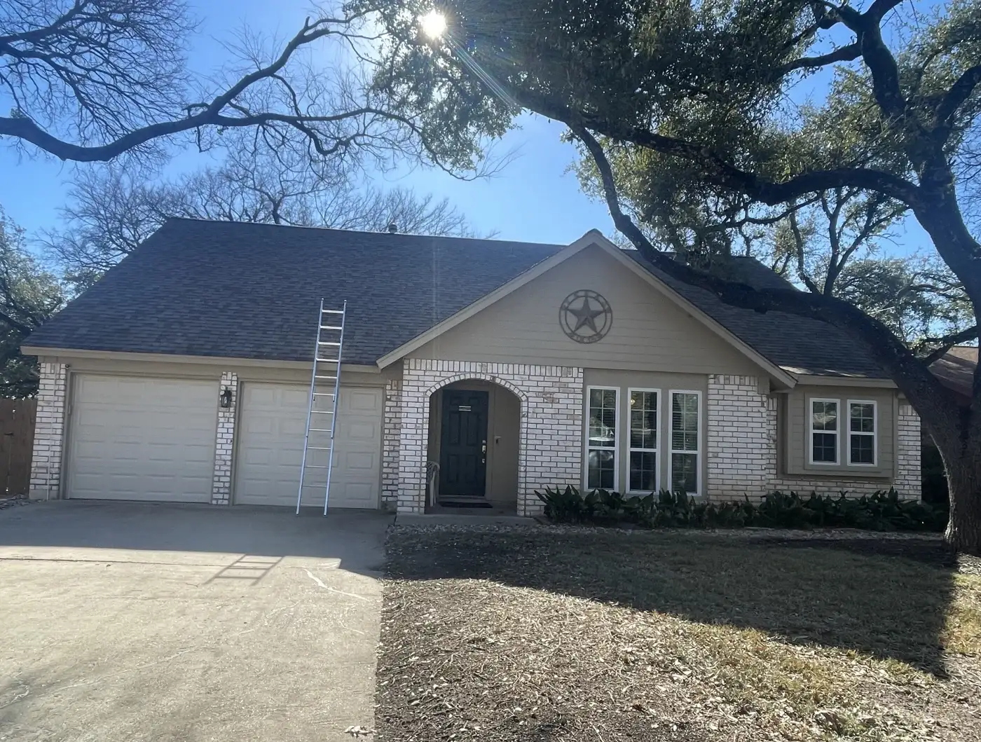 A large brick home with a new roof installed by Willi Roofing Services.