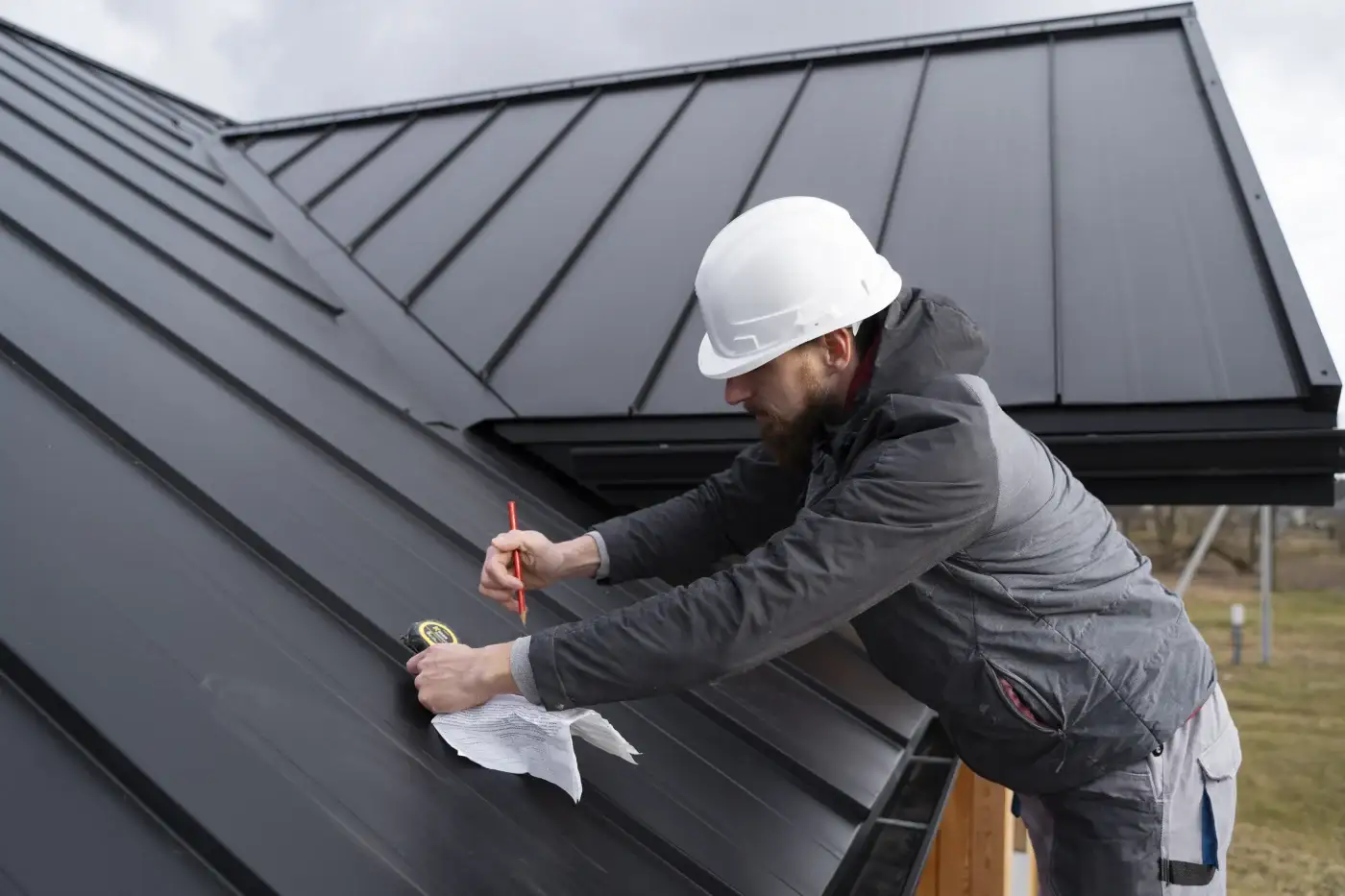 Two roofing contractors finalize the details on a metal roof.