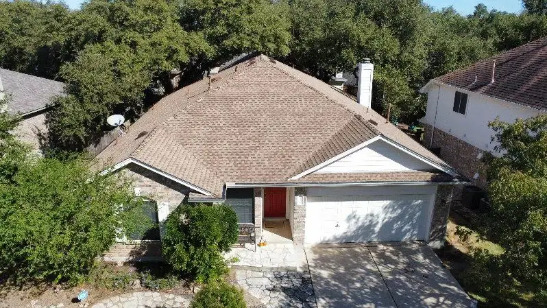An aerial view of a house with a gray asphalt shingle roof.